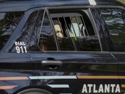Derrick Groves, the last escapee from the New Orleans jailbreak in May, sits in a police vehicle after being taken into custody by U.S. Marshals and Atlanta police at a southwest Atlanta home, Wednesday, Oct. 8, 2025. (Ben Hendren/Atlanta Journal-Constitution via AP)
