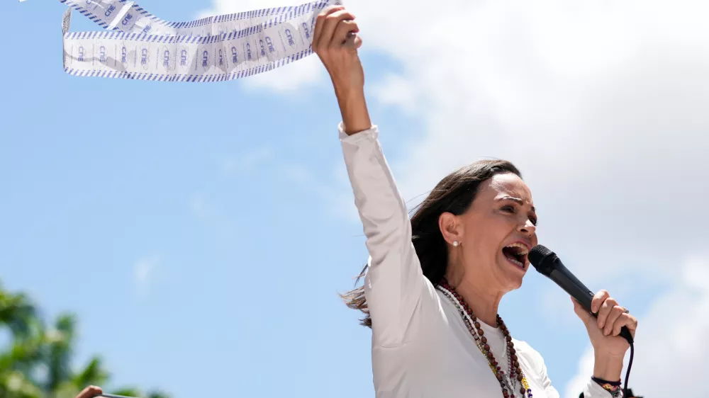 FILE - Opposition leader Maria Corina Machado holds up tally sheets during a protest against the reelection of President Nicol&aacute;s Maduro one month after the disputed presidential vote which she says the opposition won by a landslide, in Caracas, Venezuela, Aug. 28, 2024. (AP Photo/Ariana Cubillos, File)