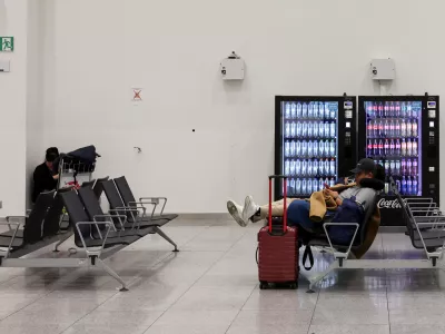 Passengers sit with their luggage as flights are cancelled, during a nationwide strike against the government's reform plans, at Brussels Airport in Zaventem near Brussels, Belgium October 14, 2025. REUTERS/Omar Havana