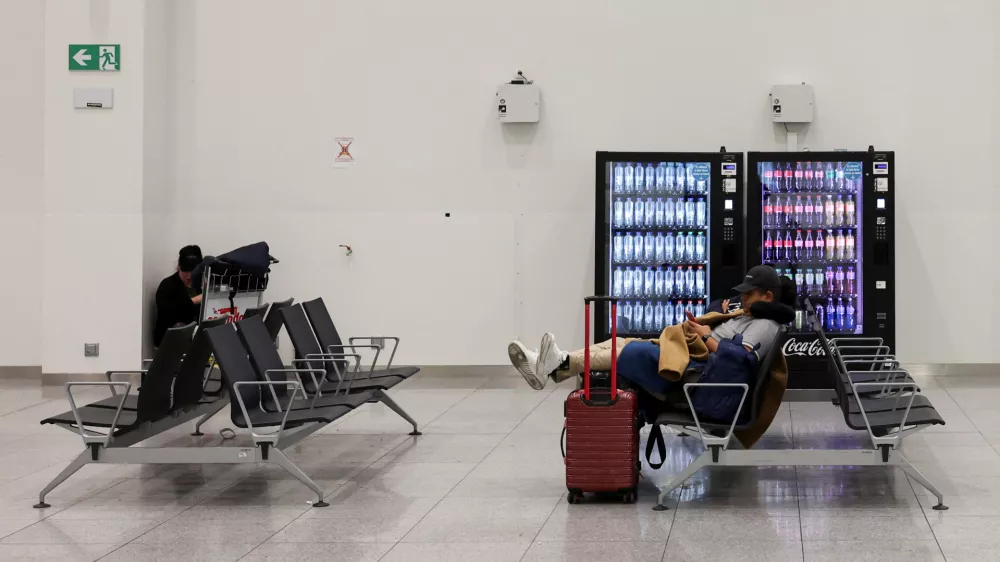 Passengers sit with their luggage as flights are cancelled, during a nationwide strike against the government's reform plans, at Brussels Airport in Zaventem near Brussels, Belgium October 14, 2025. REUTERS/Omar Havana