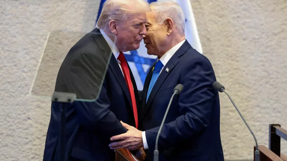 FILE PHOTO: U.S. President Donald Trump and Israeli Prime Minister Benjamin Netanyahu stand at the Knesset on the day Trump addresses it, amid a U.S.-brokered prisoner-hostage swap and ceasefire deal between Israel and Hamas, in Jerusalem, October 13, 2025. REUTERS/Evelyn Hockstein/Pool/File Photo