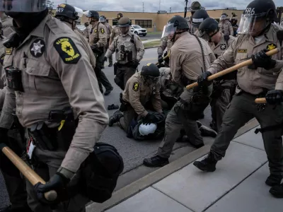 Illinois State Police move in to make detentions after declaring an unlawful assembly outside the U.S. Immigration and Customs Enforcement facility in Broadview, Ill., Saturday, Oct. 11, 2025. (AP Photo/Adam Gray)