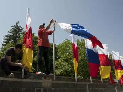 Men attach flags of South Ossetia and Russia during the preparations for an oath of allegiance military ceremony in Tskhinvali, the capital of the breakaway region of South Ossetia, Georgia, July 5, 2015. President Vladimir Putin signed a treaty with Georgia's rebel South Ossetia region on March 18 that almost completely integrates it with Russia, alarming Georgia and the West a year after Moscow took over Crimea. Russia won a five-day war with Georgia in 2008 over the fate of South Ossetia and another rebel region, Abkhazia. It formally recognizes both regions as independent states and signed a similar treaty with Abkhazia last year. Picture taken July 5, 2015. REUTERS/Kazbek Basaev
