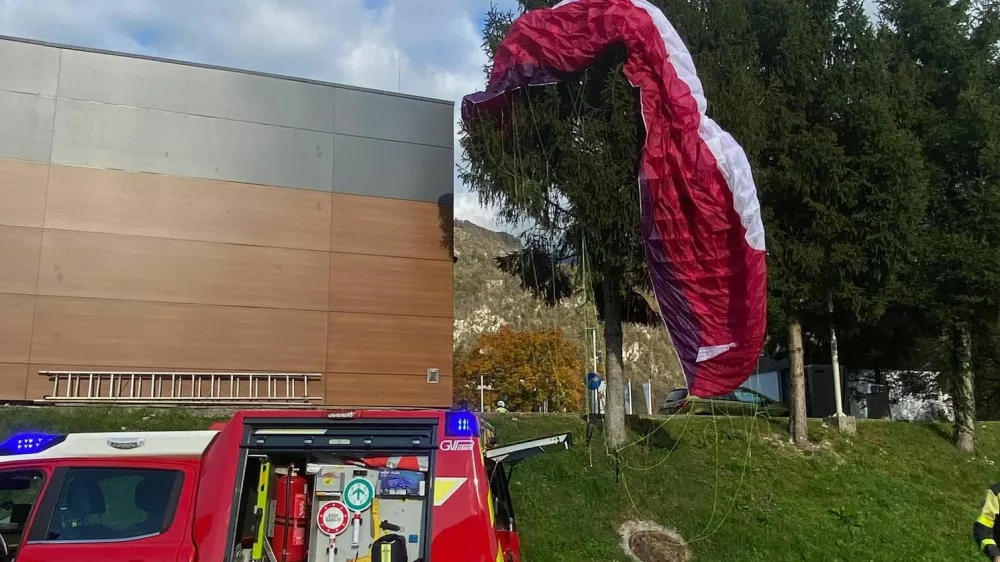 Jadralna padalka je obvisela na smreki. 