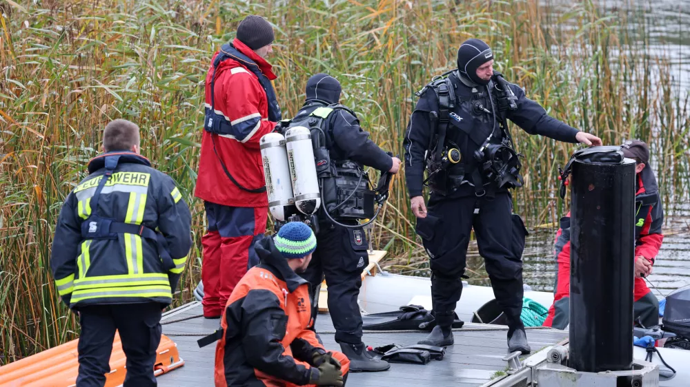 14 October 2025, Mecklenburg-Western Pomerania, Guestrow: Divers are preparing to search for missing eight-year-old Fabian at the Inselsee lake. A child's body has been found after a four-day search for a missing 8-year-old in northern Germany, with police suspecting a criminal offence in the case. Photo: Bernd W&uuml;stneck/dpa