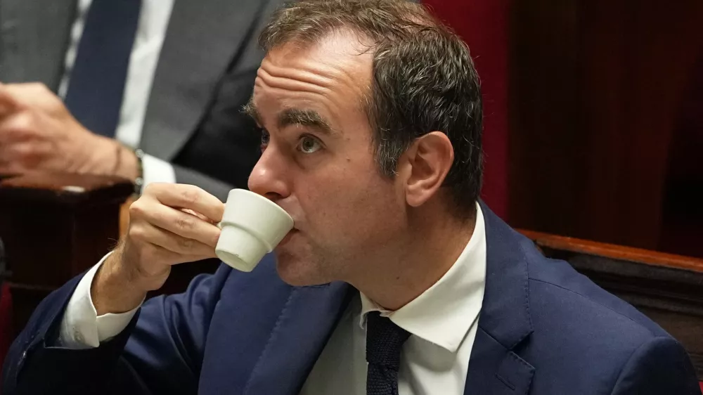 French Prime Minister Sebastien Lecornu drinks as he listens to speeches before a no-confidence vote, Thursday, Oct. 16, 2025 at the National Assembly in Paris. (AP Photo/Thibault Camus)