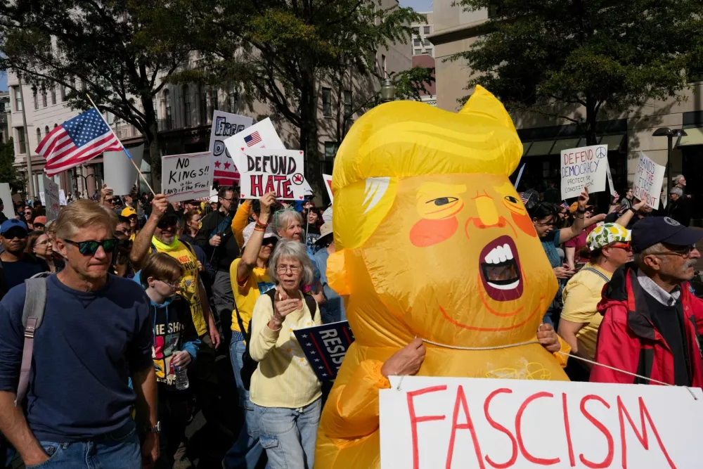 A person wearing an inflatable costume depicting U.S. President Donald Trump and demonstrators take part in a "No Kings" protest against U.S. President Donald Trump's policies, in Washington, D.C., U.S., October 18, 2025. REUTERS/Leah Millis