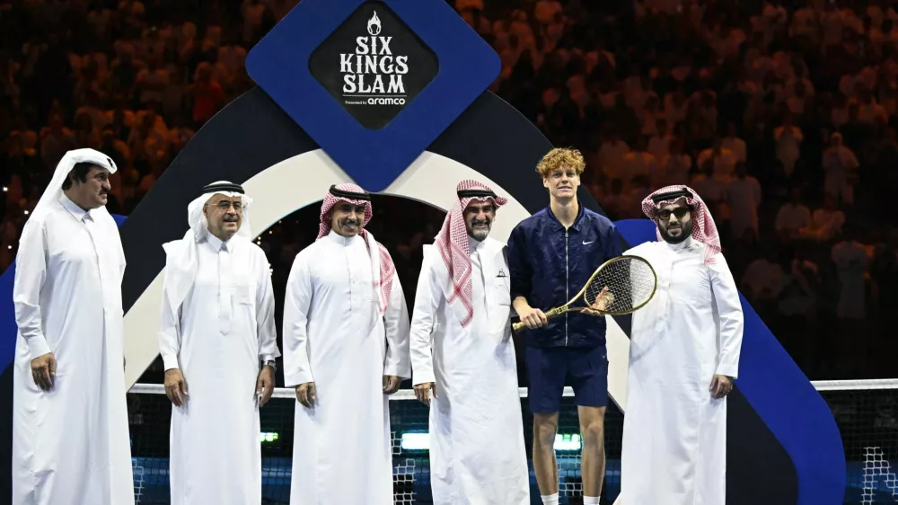 Tennis - Six Kings Slam - ANB Arena, Riyadh, Saudi Arabia - October 18, 2025 Italy's Jannik Sinner poses with a racket, Yasir Al-Rumayyan and the Chairman of Saudi Arabia's General Entertainment Authority, Turki Al-Sheikh after winning the final against Spain's Carlos Alcaraz REUTERS/Stringer