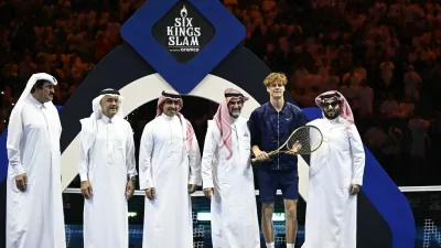 Tennis - Six Kings Slam - ANB Arena, Riyadh, Saudi Arabia - October 18, 2025 Italy's Jannik Sinner poses with a racket, Yasir Al-Rumayyan and the Chairman of Saudi Arabia's General Entertainment Authority, Turki Al-Sheikh after winning the final against Spain's Carlos Alcaraz REUTERS/Stringer