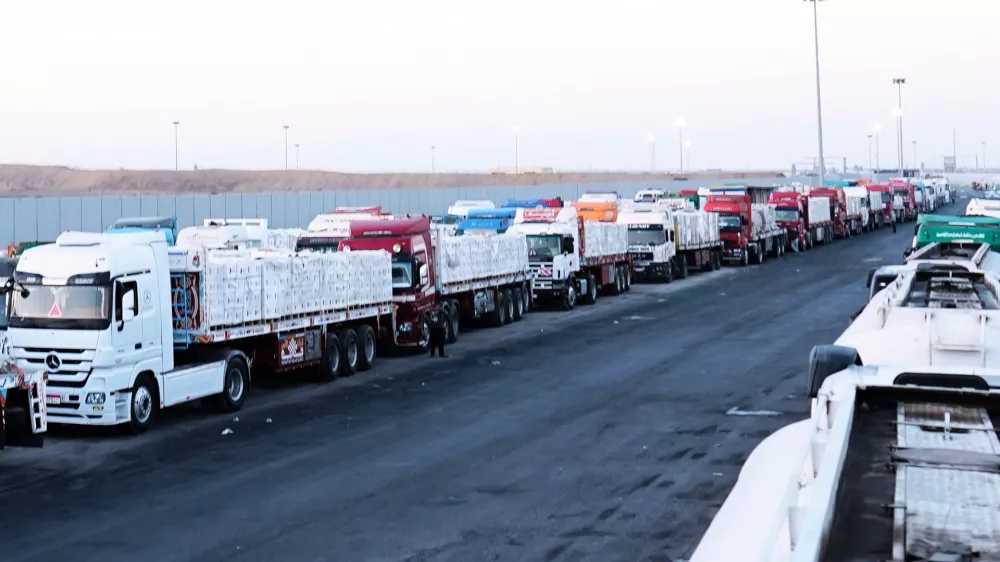 Trucks carrying humanitarian aids prepare to cross the Egyptian gate of the Rafah crossing, waiting for inspections by Israeli authorities before entering the Gaza Strip, following an agreement between Israel and Hamas on a ceasefire, Monday, Oct. 20, 2025. (AP Photo/Mohamed Arafat)