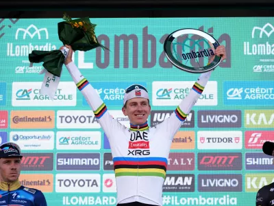 Reigning World Champion Tadej Pogacar of Slovenia, center, winner of Il Lombardia, Tour of Lombardy cycling race, celebrates on podium with second placed Belgium's Remco Evenepoel, left, and third placed Australia's Michael Storer, in Bergamo, Italy, Saturday, Oct. 11, 2025. (Gian Mattia D'Alberto /LaPresse via AP)