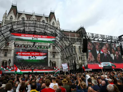 A text reading "Those who are Hungarian are coming with us" is displayed in the background as Hungarian Prime Minister Viktor Orban delivers a speech to mark the 69th anniversary of the Hungarian Uprising of 1956, in Budapest, Hungary, October 23, 2025. REUTERS/Bernadett Szabo