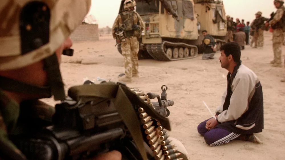 Ira&scaron;ki vojak pred strojnico ameri&scaron;kega komandosa med invazijo leta 2003. / Foto: Profimedia