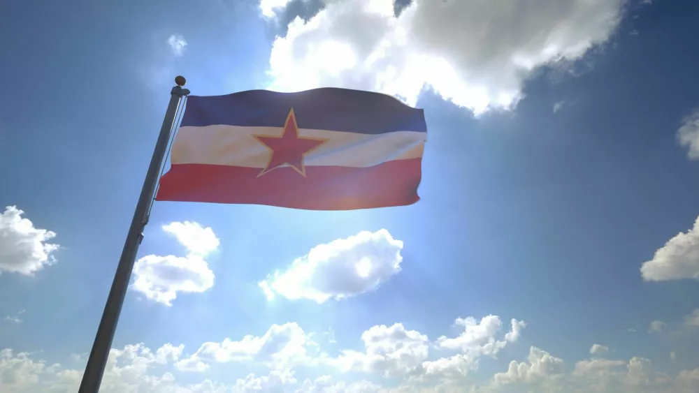 Yugoslavia Flag on a Pole with Blue Sky and Clouds in the Background / Foto: Mirza Kadic