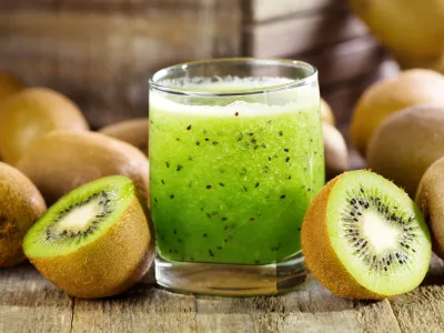 glass of kiwi juice with fresh fruits on wooden table / Foto: Nitrub