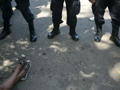 The feet of a Cuban migrant are seen in front of policemen at the border between Costa Rica and Nicaragua in Penas Blancas, Costa Rica November 17, 2015. Cubans have been making their way north from Panama to Costa Rica to Nicaragua, seeking to eventually reach the United States, where Cubans receive special treatment that welcomes them without a visa. But Nicaragua, a close ally of Cuba, closed its border with Costa Rica on Sunday to stop them. REUTERS/Oswaldo Rivas