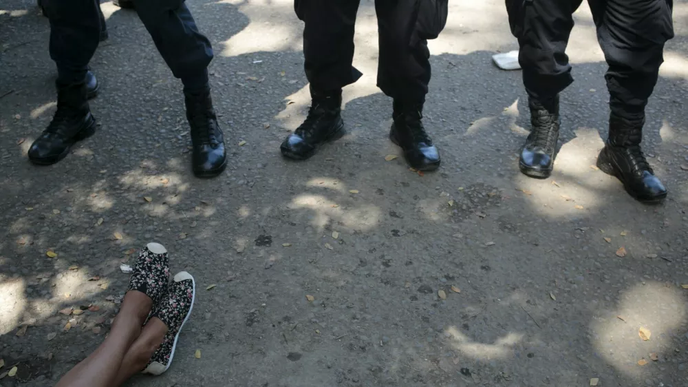 The feet of a Cuban migrant are seen in front of policemen at the border between Costa Rica and Nicaragua in Penas Blancas, Costa Rica November 17, 2015. Cubans have been making their way north from Panama to Costa Rica to Nicaragua, seeking to eventually reach the United States, where Cubans receive special treatment that welcomes them without a visa. But Nicaragua, a close ally of Cuba, closed its border with Costa Rica on Sunday to stop them. REUTERS/Oswaldo Rivas