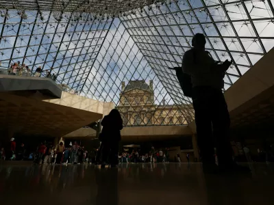 Visitors walk below the glass Pyramid at the Louvre Museum on the day it reopened to the public for the first time since last Sunday's heist, while the Galerie d'Apollon where eight pieces of Napoleon and the Empress's jewelry collection displayed in the gallery were stolen by thieves, remains closed, in Paris, France, October 22, 2025. REUTERS/Gonzalo Fuentes