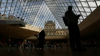 Visitors walk below the glass Pyramid at the Louvre Museum on the day it reopened to the public for the first time since last Sunday's heist, while the Galerie d'Apollon where eight pieces of Napoleon and the Empress's jewelry collection displayed in the gallery were stolen by thieves, remains closed, in Paris, France, October 22, 2025. REUTERS/Gonzalo Fuentes
