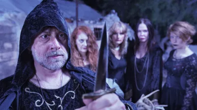 Pagan priest with ritual dagger and coven at altar