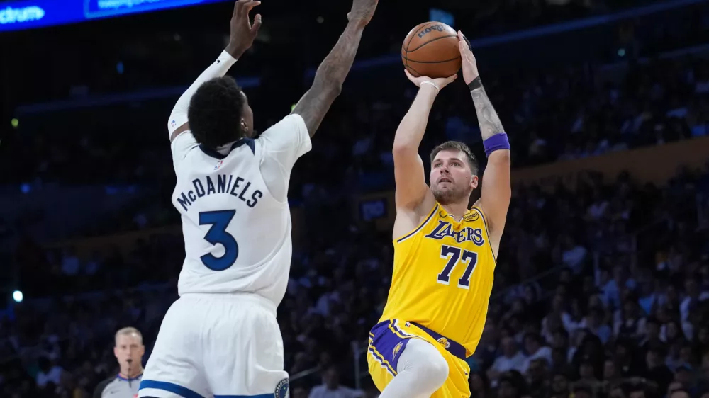 Oct 24, 2025; Los Angeles, California, USA; Los Angeles Lakers guard Luka Doncic (77) shoots the ball against Minnesota Timberwolves forward Jaden McDaniels (3) in the second half at Crypto.com Arena. Mandatory Credit: Kirby Lee-Imagn Images