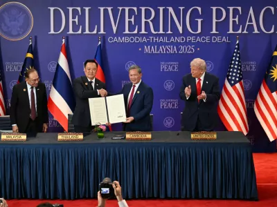 Malaysia's Prime Minister Anwar Ibrahim, left, and U.S. President Donald Trump, right, watch as Thailand's Prime Minister Anutin Charnvirakul, second left, and Cambodia's Prime Minister Hun Manet hold up a document after the ceremonial signing of a ceasefire agreement between Thailand and Cambodia on the sidelines of the 47th Association of Southeast Asian Nations (ASEAN) summit in Kuala Lumpur, Malaysia, Sunday, Oct. 26, 2025. (Mohd Rasfan/Pool Photo via AP)