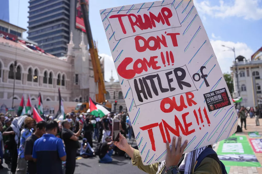 Protesters hold signs during a demonstration against U.S. President Donald Trump's attendance at the Association of Southeast Asian Nations (ASEAN) Summit in Kuala Lumpur, Malaysia, on Sunday, Oct. 26, 2025. (AP Photo/Azneal Ishak)