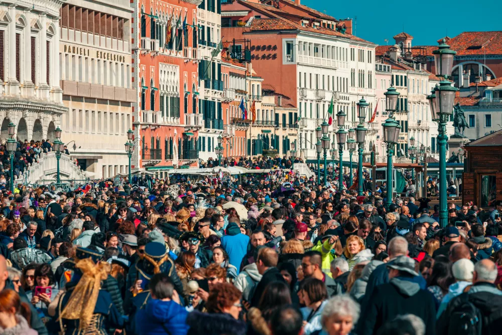 VENICE, ITALY - FEBRUARY 18, 2017: Crowds of tourists walking by typical venetian buildings near San Marco Square during famous traditional carnival taking place each year in Venice, Italy. / Foto: Rglinsky