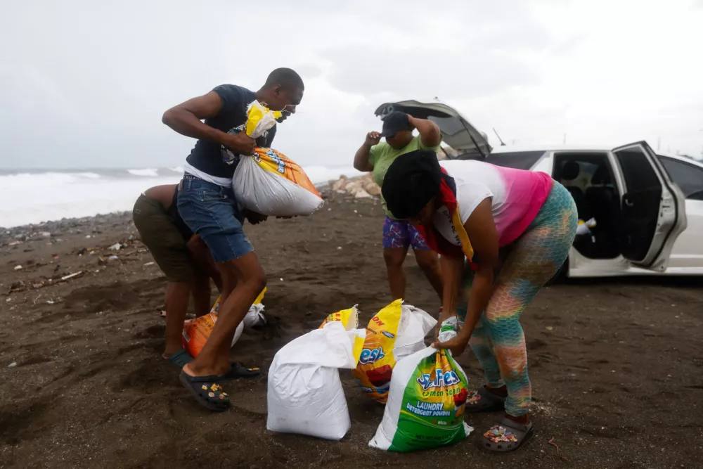 People fill bags with sand in preparation for the arrival of Hurricane Melissa, in Port Royal, Jamaica, October 26, 2025. REUTERS/Octavio Jones