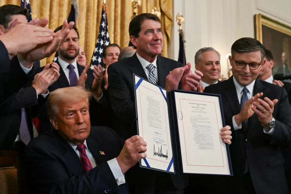 U.S. President Donald Trump holds the signed "Genius Act", which will develop regulatory framework for stablecoin cryptocurrencies and expand oversight of the industry, at the White House in Washington, D.C., U.S., July 18, 2025. REUTERS/Annabelle Gordon
