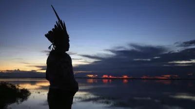 Robson Mura, of the Mura Indigenous community, watches the sunrise at the Moyray village in Autazes, Amazonas state, Brazil, Friday, Feb. 21, 2025. (AP Photo/Edmar Barros)