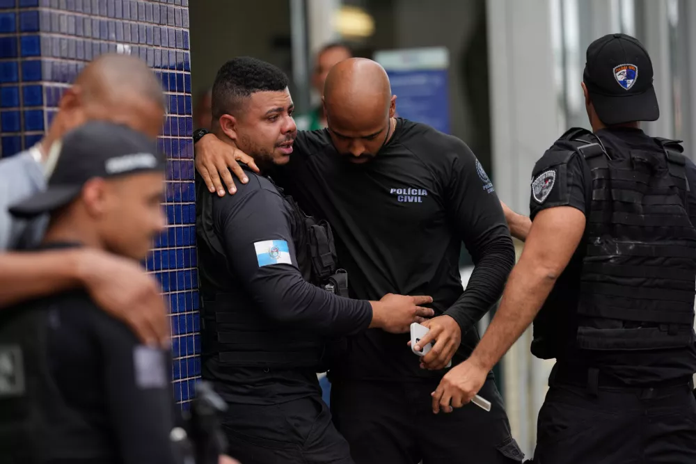 Police gather outside the Getulio Vargas Hospital where a colleague was brought after getting injured in an operation against alleged drug traffickers in the Complexo do Alemao favela where the criminal organization "Comando Vermelho" operates in Rio de Janeiro, Tuesday, Oct. 28, 2025. (AP Photo/Silvia Izquierdo)