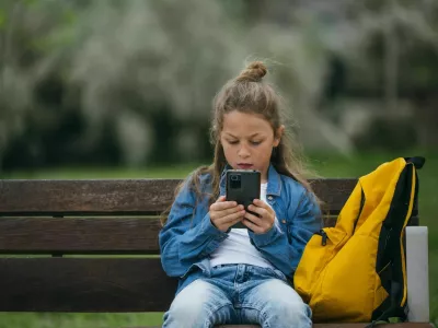 Beautiful little boy using smart phone in the park. / Foto: Jose Luis Carrascosa