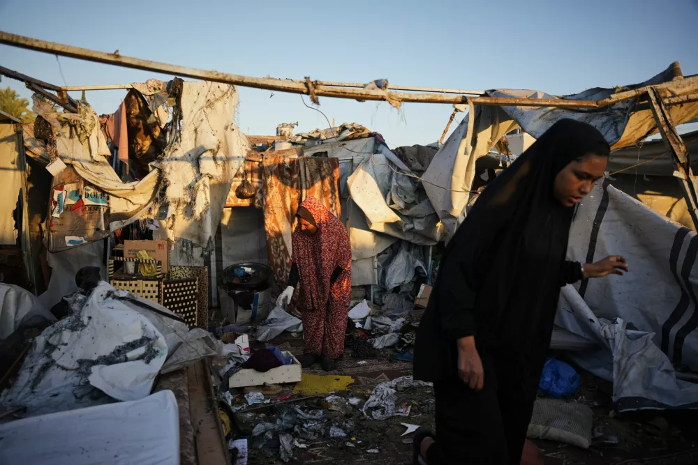 Displaced Palestinians inspect the damage after an Israeli army strike on their tent camp in Deir al-Balah, Gaza Strip, Wednesday, Oct. 29, 2025. (AP Photo/Abdel Kareem Hana)
