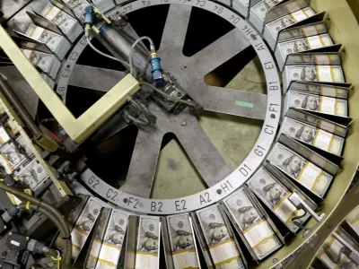 FILE - In this Sept. 24, 2013 file photo, freshly cut stacks of 0 bills make their way down the line at the Bureau of Engraving and Printing Western Currency Facility in Fort Worth, Texas. (AP Photo/LM Otero, File)