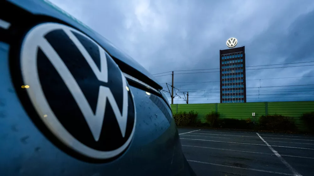 30 October 2025, Lower Saxony, Wolfsburg: A Volkswagen parked in front of the Volkswagen brand tower at the site of the VW main plant. Photo: Julian Stratenschulte/dpa