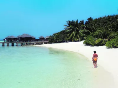 Renate Reinstaller, a tourist from Meran, Italy, walks a beach at the Baros Resort Island in the Maldives Saturday, Jan. 15, 2005. With French charter flights likely to resume soon and Italy lifting a warning against travel to the Indian Ocean archipelago, authorities are hoping that the balm of tourism would ease the impact of the Dec. 26 tsunami on Maldives. (AP Photo/Ed Wray)------3k