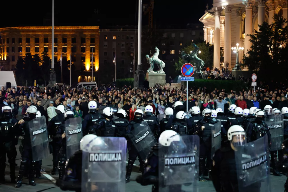 Serbian riot police separate rival crowds of opponents and loyalists of autocratic President Aleksandar Vucic, a day after tens of thousands of people joined a huge rally in the northern city of Novi Sad marking the first anniversary of a train station disaster there that killed 16 people, in Belgrade, Serbia, Sunday, Nov. 2, 2025. (AP Photo/Marko Drobnjakovic)