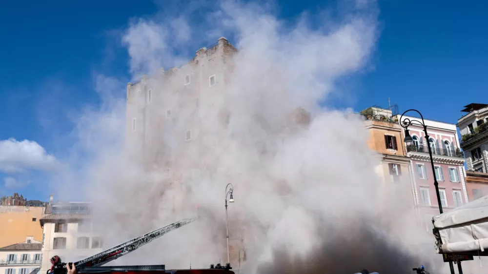 Dust rises as part of the Torre dei Conti tower collapses following an earlier partial collapse, near Via dei Fori Imperiali, near the Colosseum, in Rome, Italy, November 3, 2025. REUTERS/Remo Casilli   TPX IMAGES OF THE DAY
