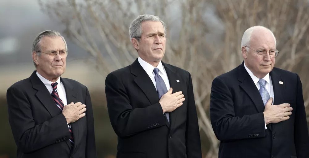 U.S. President George W. Bush, Vice President Dick Cheney (R) and outgoing Secretary of Defense Donald Rumsfeld (L) place their hands over their hearts as the national anthem is played at Rumsfeld's farewell tribute at the Pentagon in Arlington, Virginia, December 15, 2006. Rumsfeld will be replaced by former CIA director Robert Gates.  REUTERS/Kevin Lamarque (UNITED STATES)