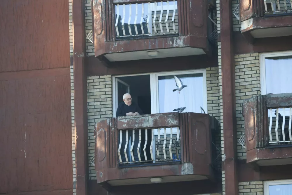 A man at an elderly people's home feeds pigeons, in an undamaged part of the building after a fire at the elderly people's home, in the town of Tuzla, Bosnia and Herzegovina, November 5, 2025. REUTERS/Amel Emric