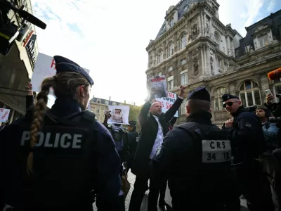 Supporters of the Association Mouv'Enfants hold placards in front of French police during a protest against the opening of the first physical space of Chinese online fast-fashion retailer Shein at the Le BHV Marais department store, the Bazar de l'Hotel de Ville, in Paris, France, November 5, 2025. REUTERS/Sarah Meyssonnier