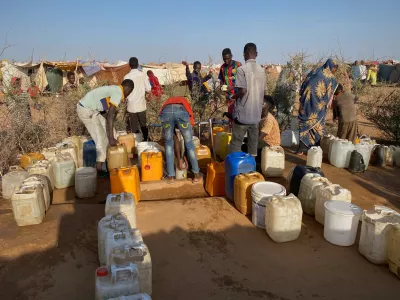 Sudanese men who fled el-Fasher city, after Sudan's paramilitary forces killed hundreds of people in the western Darfur region, collect water at a camp in Tawila, Sudan, Saturday, Nov. 1, 2025. (AP Photo/Mohammed Bakry)