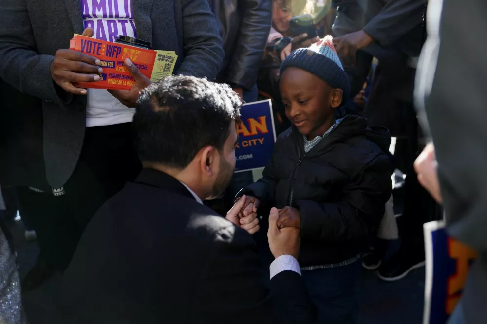 Democratic candidate for New York City mayor, Zohran Mamdani greets a child, during the New York City mayoral election, at the PS 20 The Clinton Hill School, in the Brooklyn borough of New York City, U.S., November 4, 2025. REUTERS/Kylie Cooper