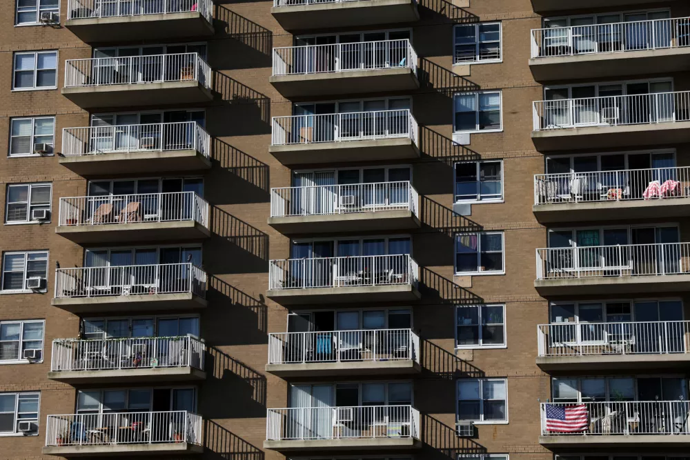 The United States flag hangs from a balcony at an apartment complex in the Rockaway Beach neighborhood in the Queens borough of New York City, U.S., October 6, 2025. REUTERS/Shannon Stapleton