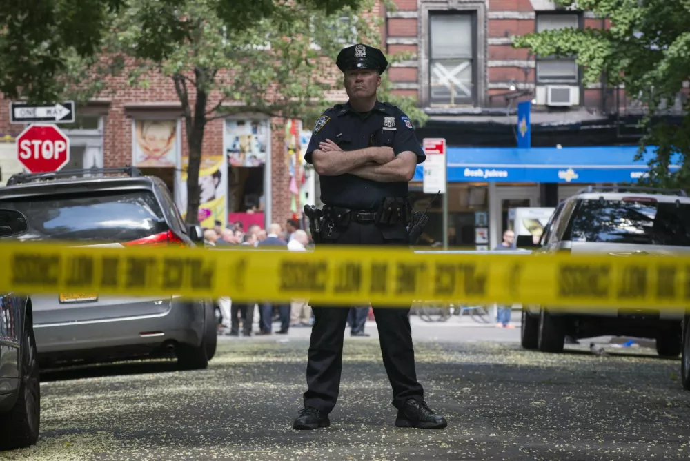 A New York Police Officer stands guard inside a cordoned area at the site of a shooting in Greenwich Village, Manhattan, New York July 28, 2014. Two U.S. Marshals and a New York City police detective were shot and wounded on Monday and a man was killed during an attempt to arrest him in the city's Greenwich Village neighborhood on suspicion of sex abuse, the police said. The wounded law enforcement agents were hospitalized, New York Police Department Commissioner William Bratton said at a news conference. REUTERS/Darren Ornitz (UNITED STATES - Tags: CRIME LAW)
