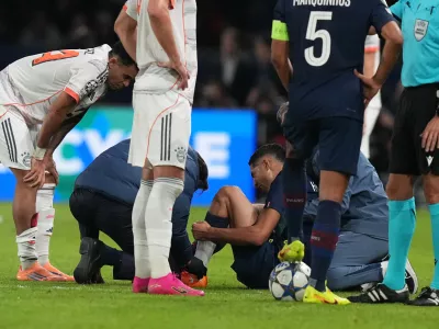 PSG's Achraf Hakimi sits on the ground injured during the Champions League opening phase soccer match between Paris Saint-Germain and Bayern Munich in Paris, France, Tuesday, Nov. 4, 2025. (AP Photo/Thibault Camus)