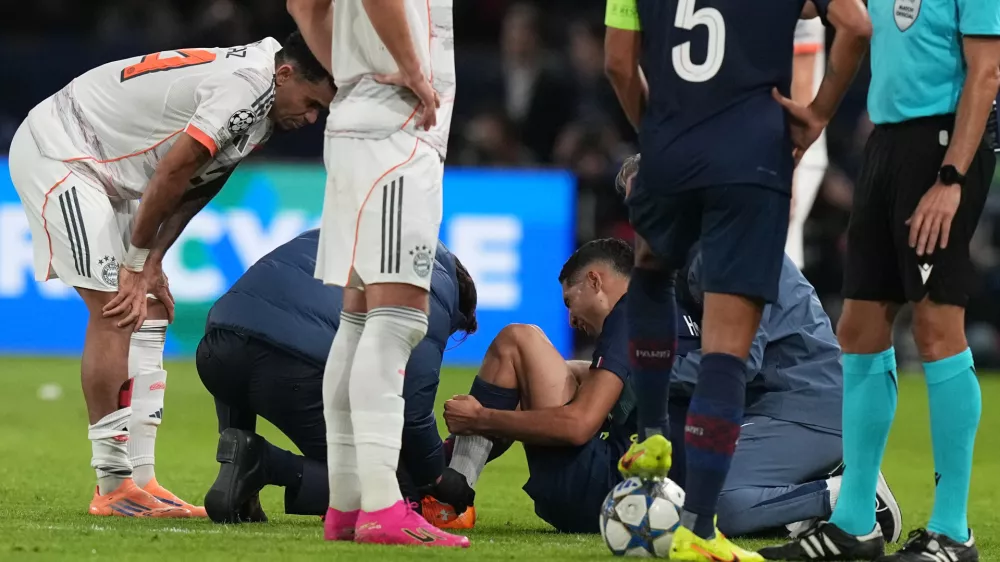 PSG's Achraf Hakimi sits on the ground injured during the Champions League opening phase soccer match between Paris Saint-Germain and Bayern Munich in Paris, France, Tuesday, Nov. 4, 2025. (AP Photo/Thibault Camus)