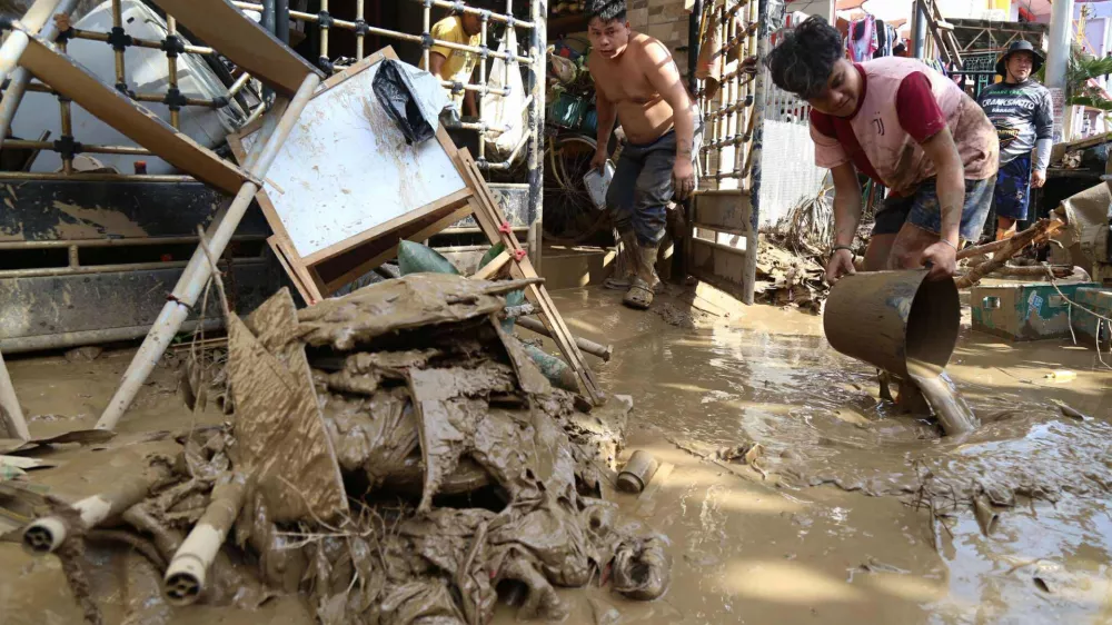 Residents clean up outside their homes after Typhoon Kalmaegi caused devastation in communities at Talisay City, Cebu province, central Philippines, Wednesday, Nov. 5, 2025. (AP Photo/Jacqueline Hernandez)