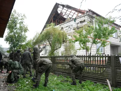 FILE - Territorial defense officers clean up debris from the destroyed roof of a house in Wyryki near Lublin, Poland, after Russian drones violated Polish airspace during an attack on Ukraine, on Sept. 11, 2025. (AP Photo/Czarek Sokolowski, File)